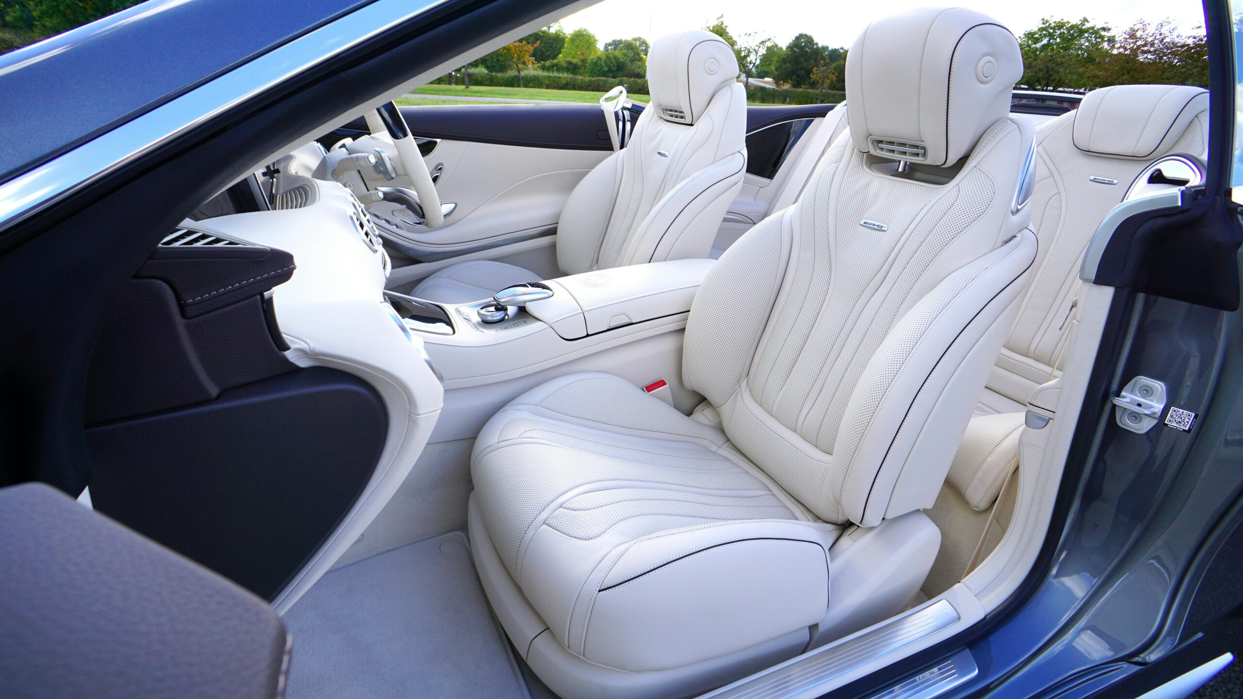 Explore the elegance of a luxury car interior with pristine white leather seats and advanced design features.