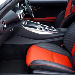 Sleek, modern car interior featuring red and black leather seats and advanced dashboard controls.